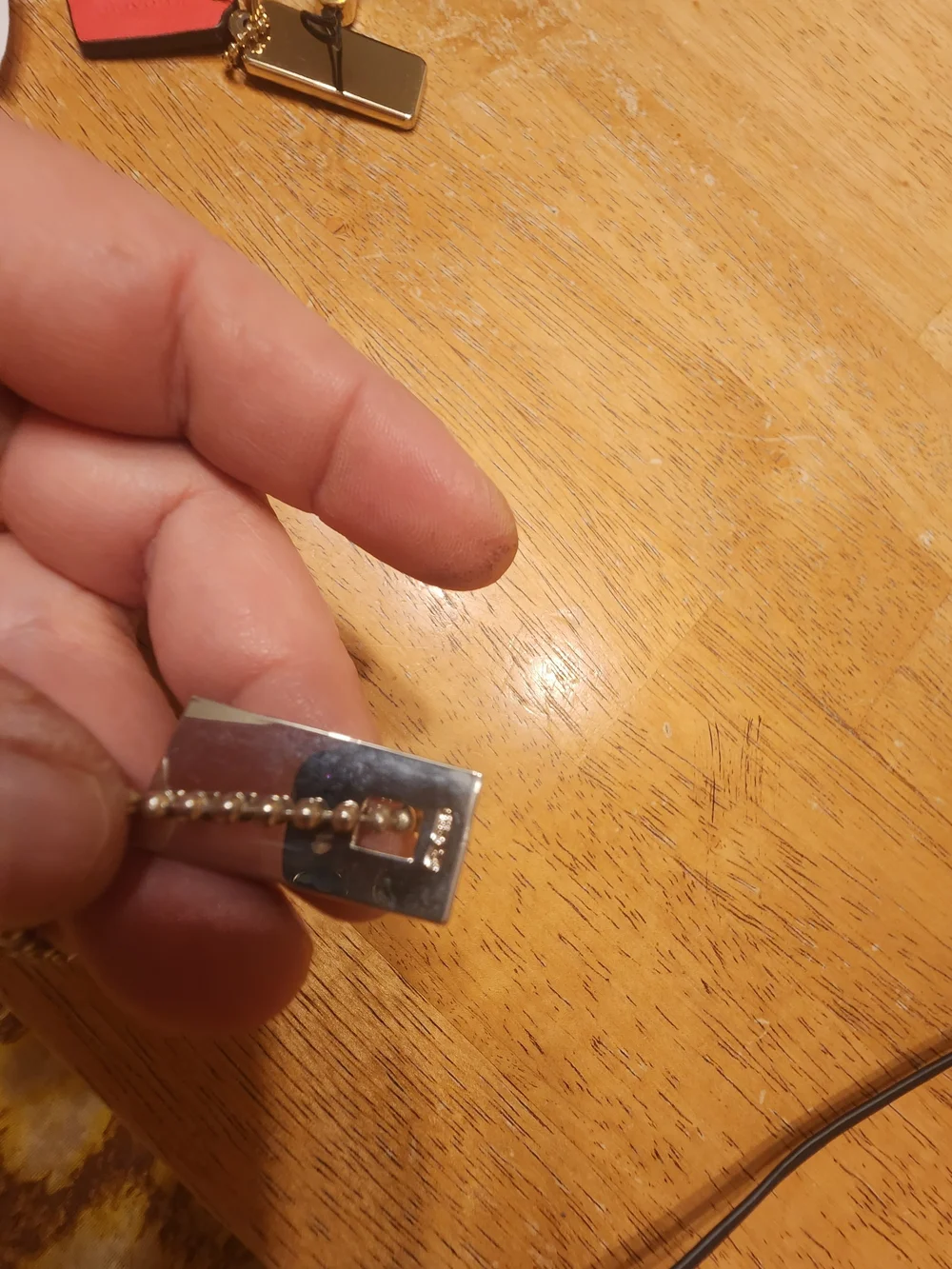 Gucci Sterling Silver Logo Tag likely used on a bracelet or keychain